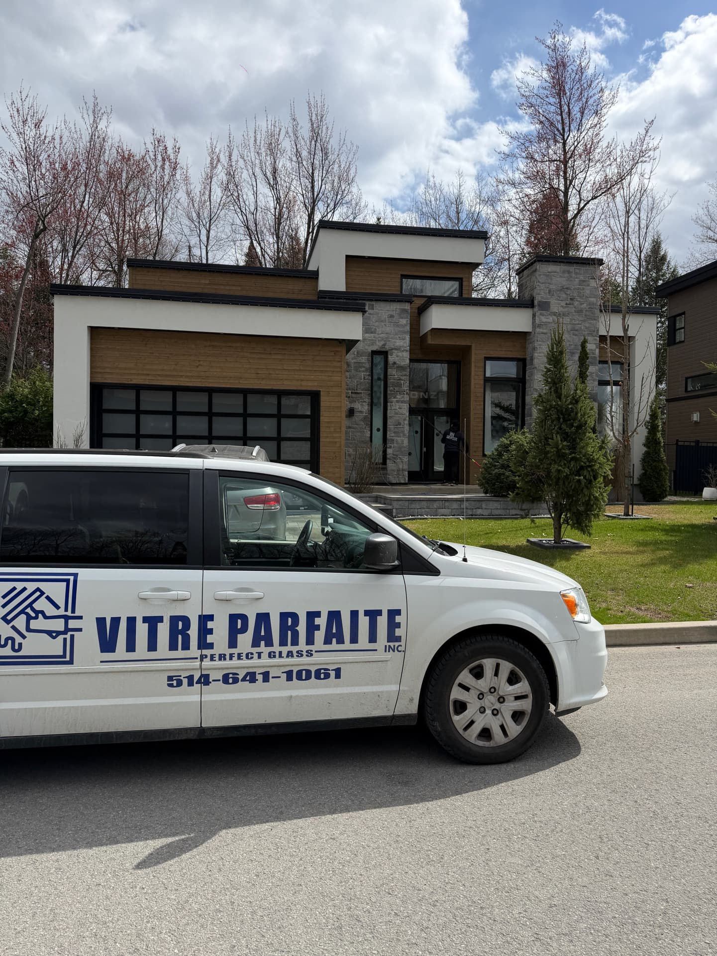 Camionnette Vitre Parfaite devant une maison moderne pendant le nettoyage des vitres de l’entrée
