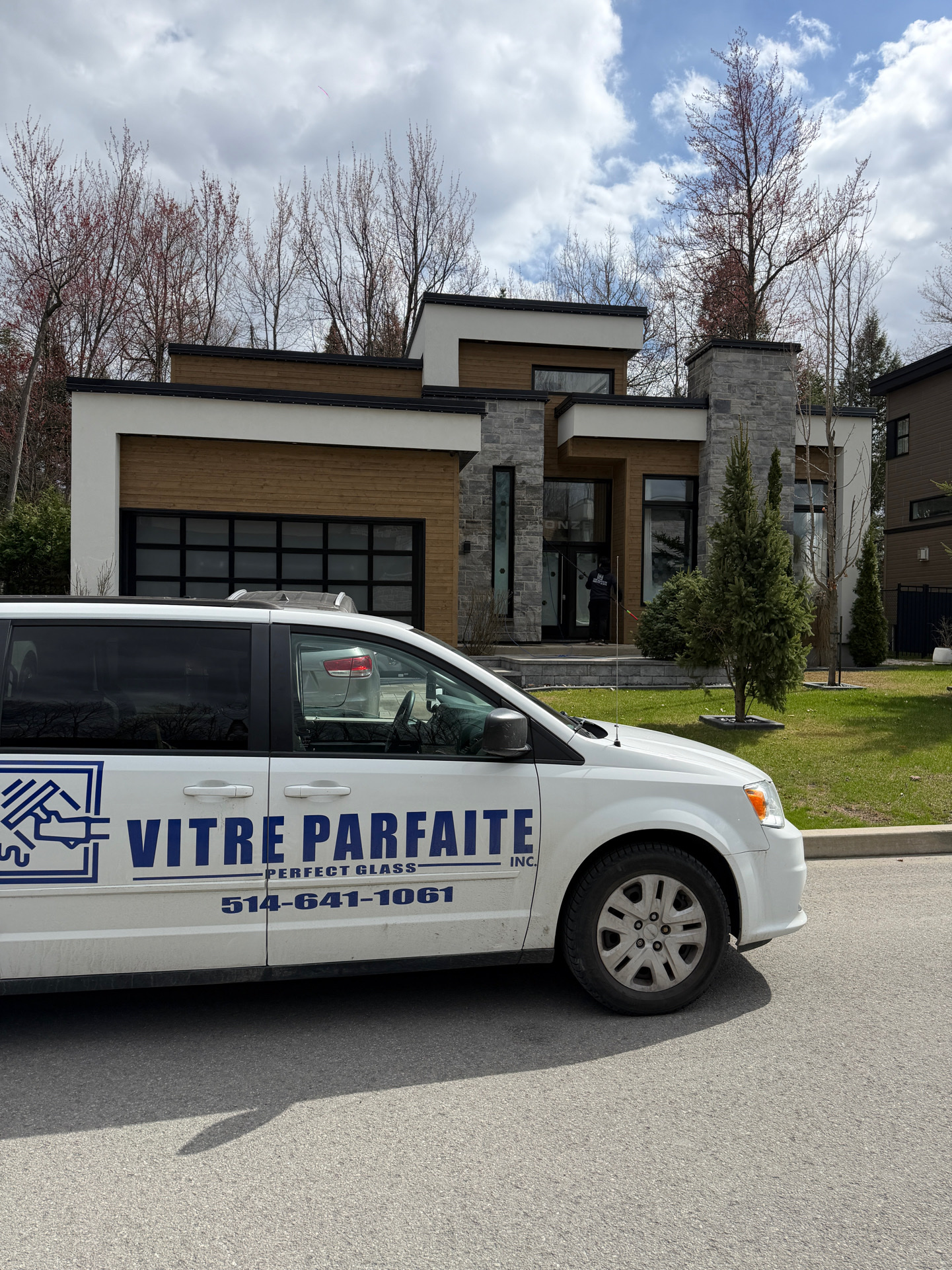 Camionnette Vitre Parfaite devant une maison moderne pendant le nettoyage des vitres de l’entrée
